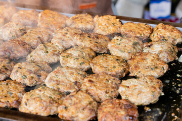 A sizzling, golden-brown pork cutlet freshly fried at a lively night market. The crispy coating and juicy meat inside make it a popular Taiwanese street food, tempting visitors with its aroma and irre