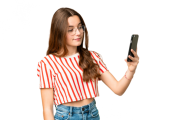 Teenager girl over isolated chroma key background making a selfie