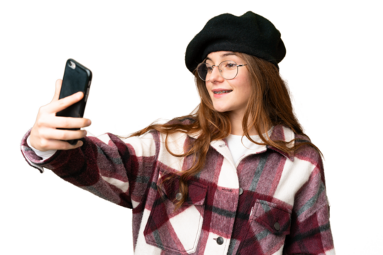 Teenager girl over isolated chroma key background making a selfie with mobile phone