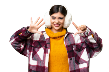 Young Russian woman wearing winter muffs over isolated chroma key background counting seven with fingers