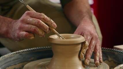 Close up unrecognizable Caucasian man guy potter artist ceramist small business owner craftsperson male hands shaping clay mud brown dirt ceramic using equipment tool work on spinning wheel at studio - Powered by Adobe