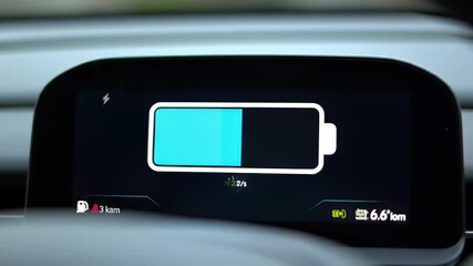 Electric car's dashboard displays battery charging status, showing the progress in modern automobile, with close-up shot and eco-friendly technology concept. - Powered by Adobe