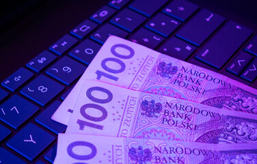 Polish banknotes lying on a computer keyboard, technology industry