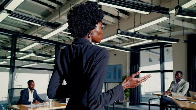 Female boss presenting during team meeting