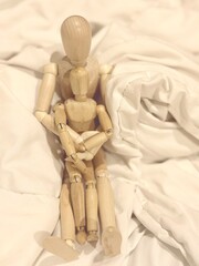 Photo Of A Wooden Figurine Doll Sitting With A Smaller Wooden Figurine Like A Family
