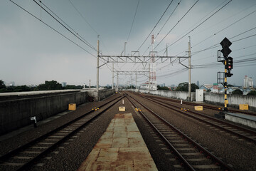 Obraz premium From a train platform's end, a broad view reveals numerous overhead cables, essential for powering commuter electric trains and vital for reliable mass transit, emphasizing maintenance's critical role