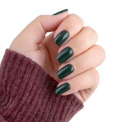 Stylish hand with green nail polish holding a cozy winter sweater. Perfect representation of fashion and beauty trends for the colder months.