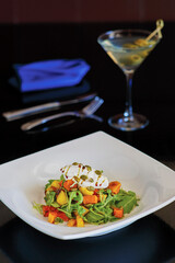 mixed green salad topped with butternut squash and burrata