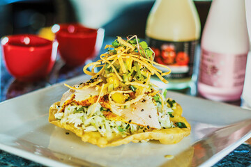 blackened fish tostado topped with fresh coleslaw and 