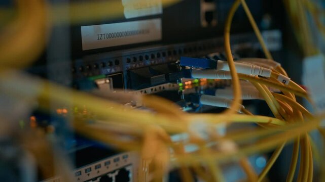 Close up shot of cables and wires connected to supercomputing equipment with blinking indicators in server room