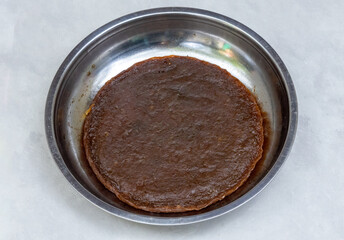 Tasty Amsotto, a traditional Bengali mango bar (Aam Papad) on a steel plate. Sweet sun-dried mango fruit leather.