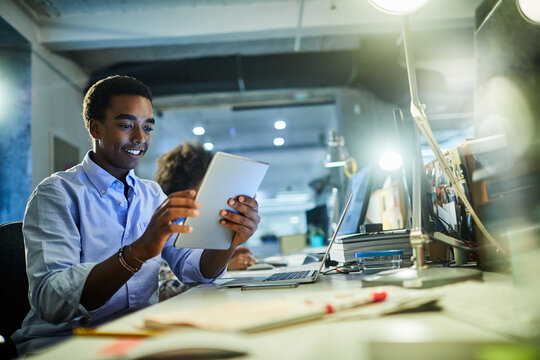 Confident young man working on a digital tablet in a modern office setting