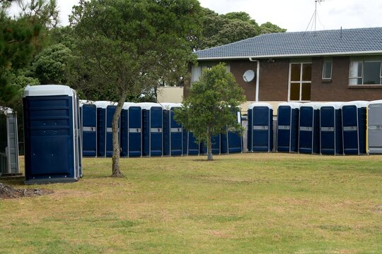 Rows of Portable Toilets on Lush Green Lawn Outdoors