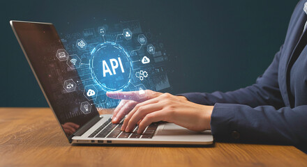A person typing on a laptop with api graphic overlay and icons surrounding the central design