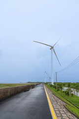 Wind turbines on the roadside under dark clouds