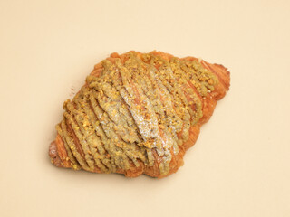 Freshly baked pastry with topping, on beige background
