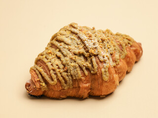 Freshly baked pastry with topping, on beige background