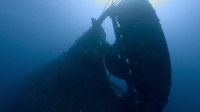 The wreck of the Lavanzo, lying between Egypt and Sudan in the Red Sea, appears in a dramatic backlit shot with its large propeller clearly visible. Check my portfolio for more Lavanzo wreck footage.