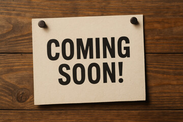 A bold announcement on textured paper pinned to wood symbolizes an upcoming event creating anticipation and signaling future progress