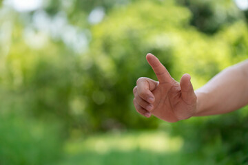 A hand reaching out against a soft green background, symbolizing connection, guidance, or the act of giving/receiving. Ideal for concepts of nature, help, or interaction.