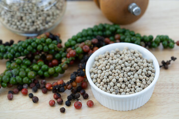 Vibrant peppercorns and aromatic herbs: nature's essence for healthy living and flavorful dishes. Perfect for culinary and wellness themes.