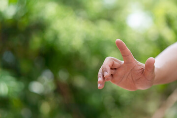 A hand reaching out against a soft green background, symbolizing connection, guidance, or the act of giving/receiving. Ideal for concepts of nature, help, or interaction.