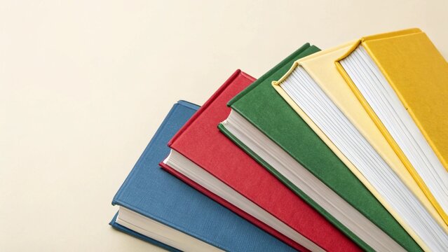Books lined up in rows on a solid color background.