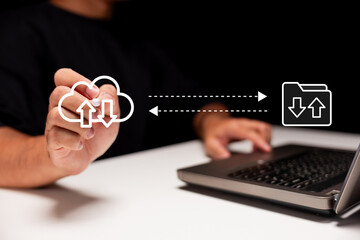 A person interacts with cloud storage icons, symbolizing file upload and download between a laptop and the cloud in a digital data exchange concept.