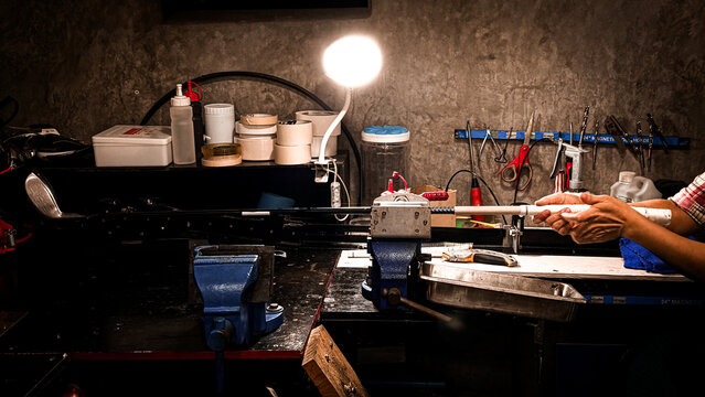 Okay, here's a more specific description focusing on golf club grip maintenance: Golf club grip maintenance on workbench. Workshop, sport equipment, repair,