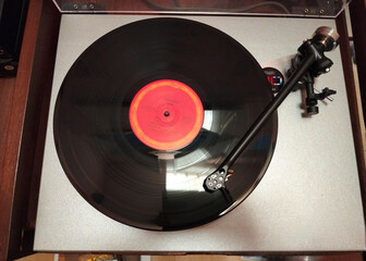 Vintage Turntable with Vinyl Record on Wooden Table. Classic Record Player Spinning a Retro Vinyl Disc