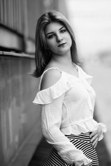 Black and white portrait of a young beautiful long-haired girl outdoors.