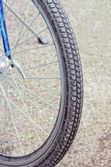 Fototapeta premium part of a wheel made of gray black rubber tire and metal spokes on a bike in the street