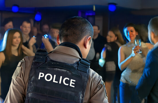 A police officer inspects a nightclub with guests enjoying social activities and entertainment.