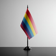 Rainbow flag displayed on a black stand against a minimalist backdrop  