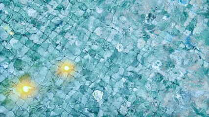 Swimming pool tile surface with glowing underwater lights and water ripple texture
