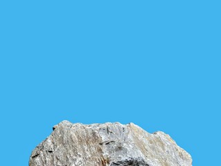 Stone podium rock stand isolated on cyan background with clipping path for product display presentation backdrop.