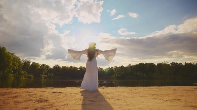  unrecognizable silhouette happy fantasy woman goddess walks by river, blue sky sun light green forest nymph fairy tale elf. Beauty girl enjoy summer nature back rear view long black hair white dress