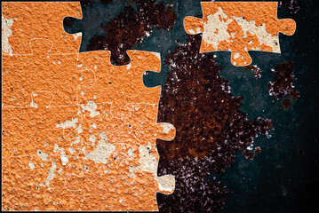Pieza de rompecabezas sobre una superficie metálica oxidada con pintura desgastada. Concepto de...
