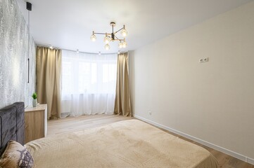 cozy bedroom features a brown bed, forest-themed wallpaper, neutral curtains, and light wood...
