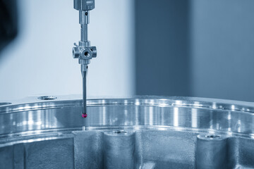 The CMM machine measuring the automotive parts by modular probe in the light blue scene.