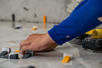 man's hands using equipment for leveling and spacing floors