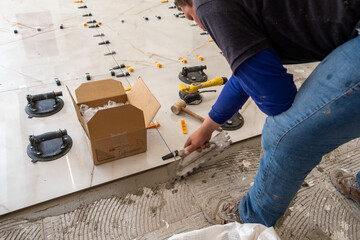 man's hands using equipment for leveling and spacing floors
