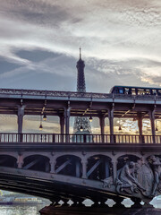 Lumière matinale à Paris avec le métro qui passe sur le pont Bir Hakeim devant la Tour Eiffel