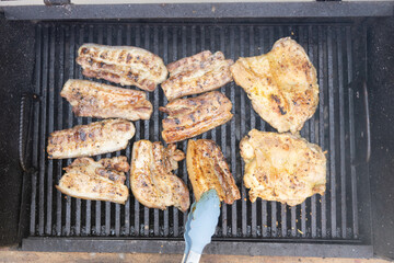 A close-up of grilled meats sizzling on a barbecue, highlighting the appetizing appeal of summer...
