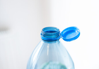 Plastic cap connected to a plastic bottle. Bottle design with the cap attached to the bottle for easier recycling of waste.