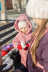 Grandfather playing with her granddaughters on the playground in the park in winter