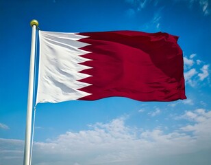 Naklejka premium Qatar flag waving on a pole. The flag of Qatar features maroon and white colors. Qatar flag .jpg