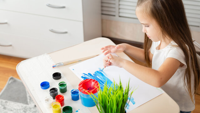 Child girl playing with digital wireless tablet computer on bed at home.