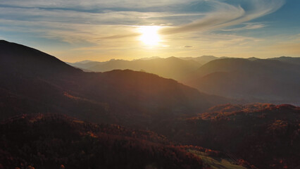 Flying over colorful foliage at sunset in mountains