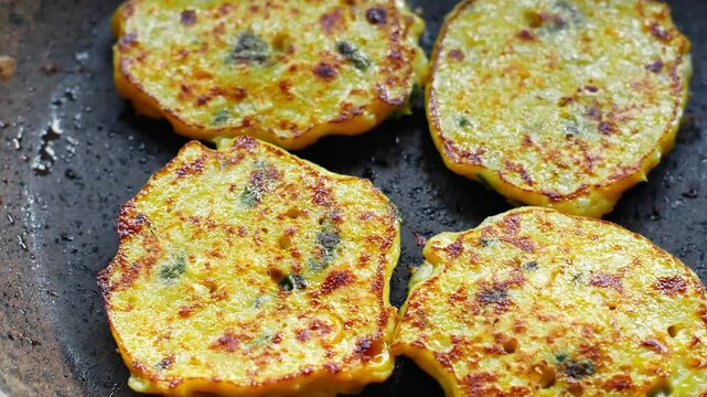 Frying homemade corn fritters to serve on the family dining table. Close-up video of corn fritters fried on a teflon pan.